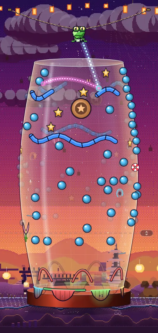 Drazzle gameplay: a tall glass cylinder hung with paper lanterns, blue brick rails and golden stars, the frog shooter waiting on a rope above it